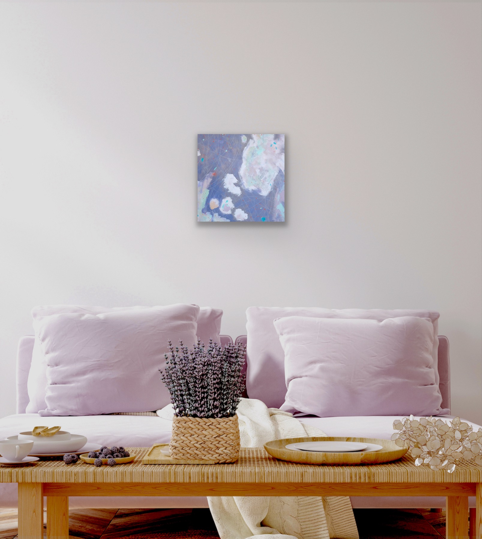 A square abstract painting in a sitting room hanging above a sofa