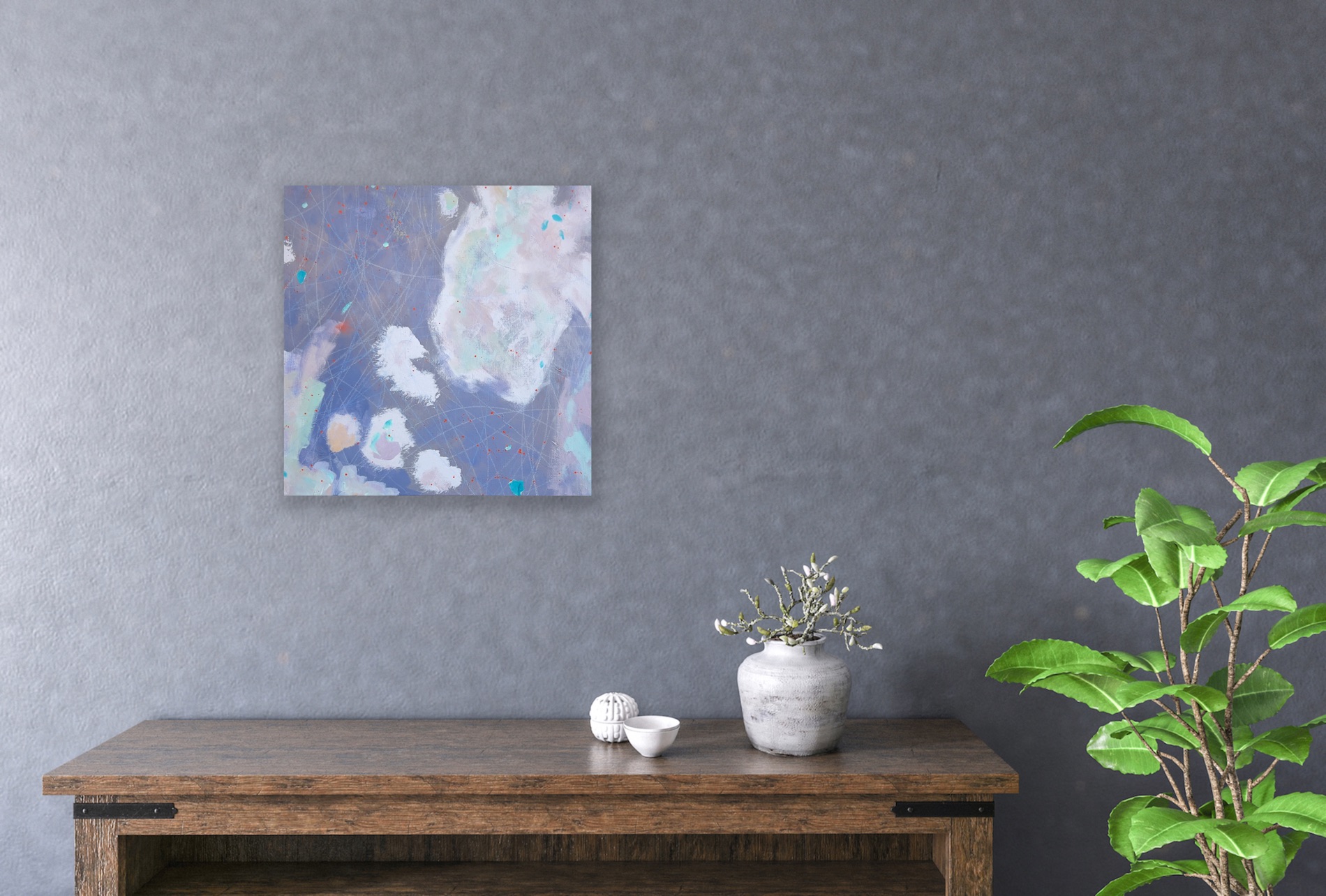 An abstract painting in soft greys hanging on a wall above a table