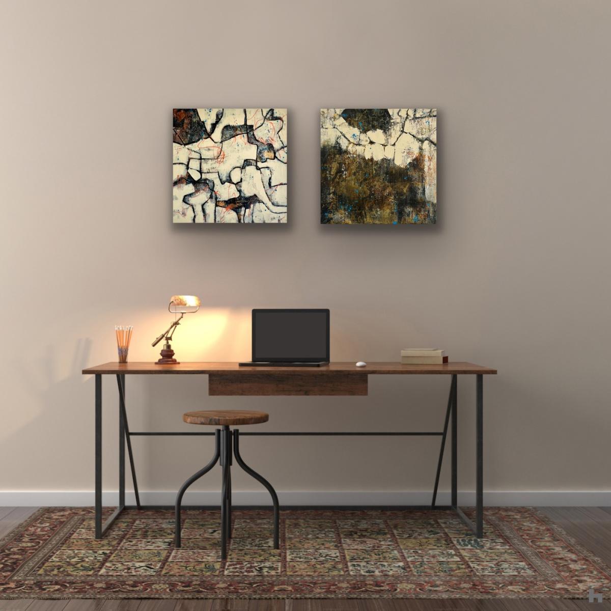 Two small black paintings hanging on a wall above a desk
