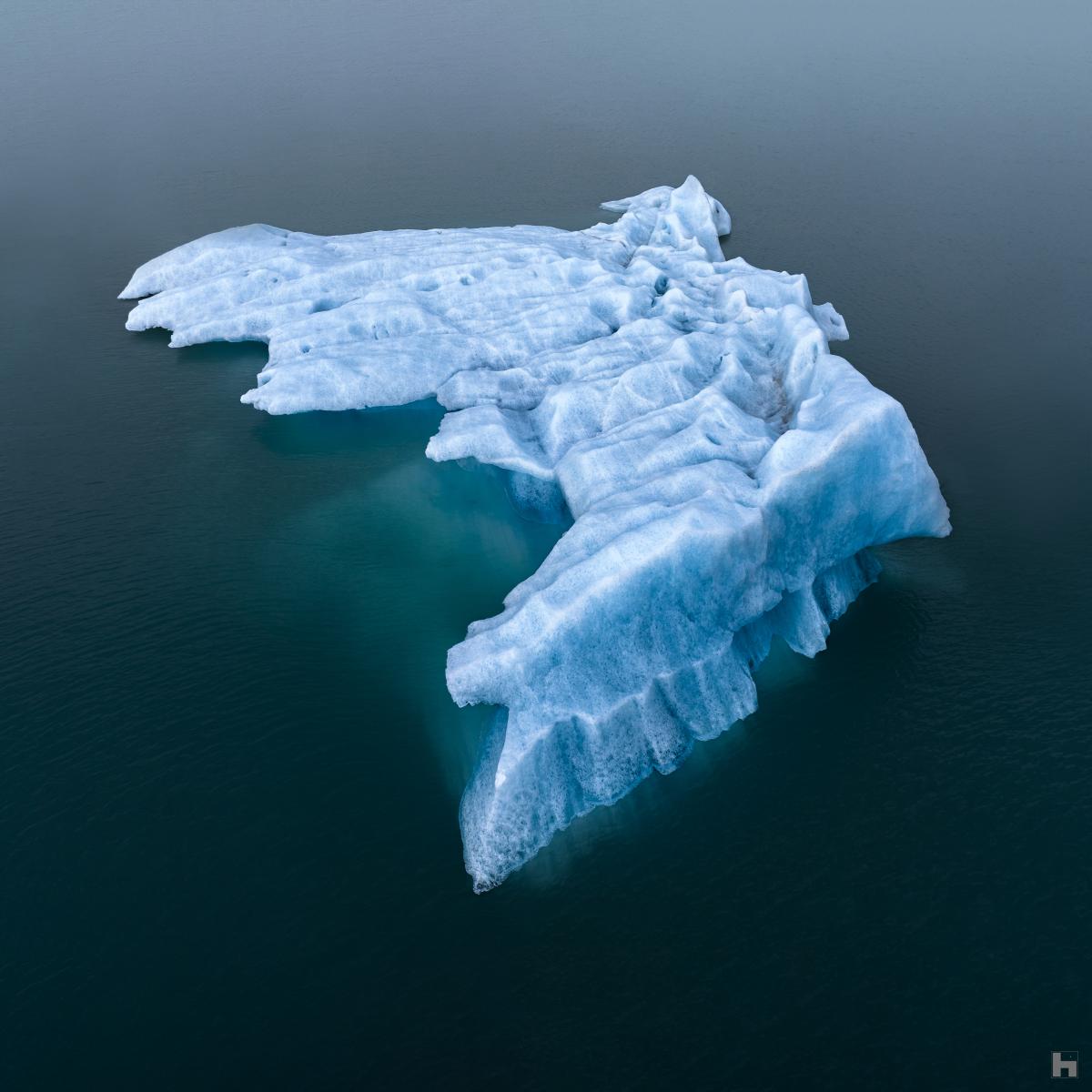 Un iceberg se montre pendant une courte durée avant de dériver dans la mer.