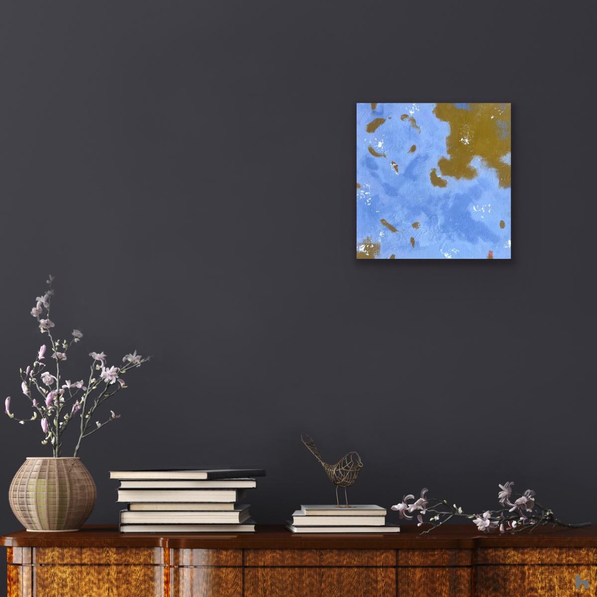 A photo of a small square blue painting on a dark blue background