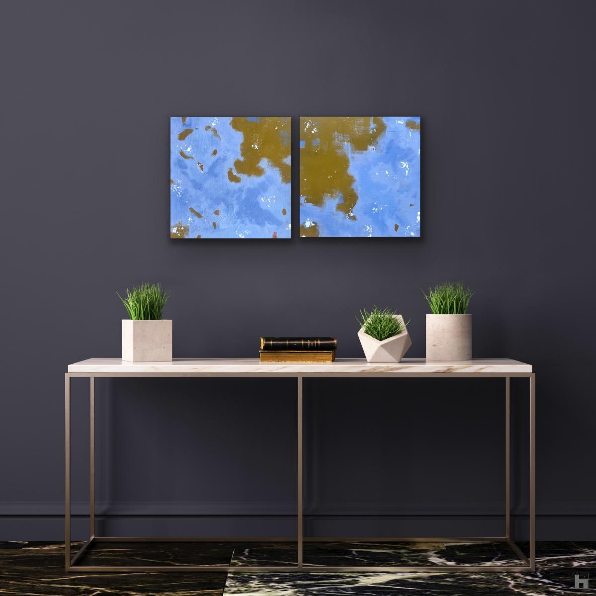Two small blue paintings on a dark wall