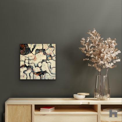 A small abstract painting on a grey wall