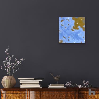 A photo of a small square blue painting on a dark blue background