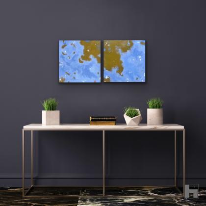 Two small blue paintings on a dark wall