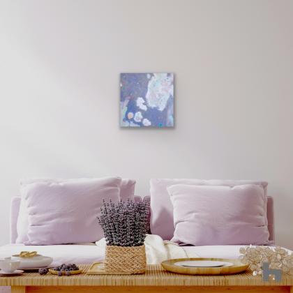 A square abstract painting in a sitting room hanging above a sofa